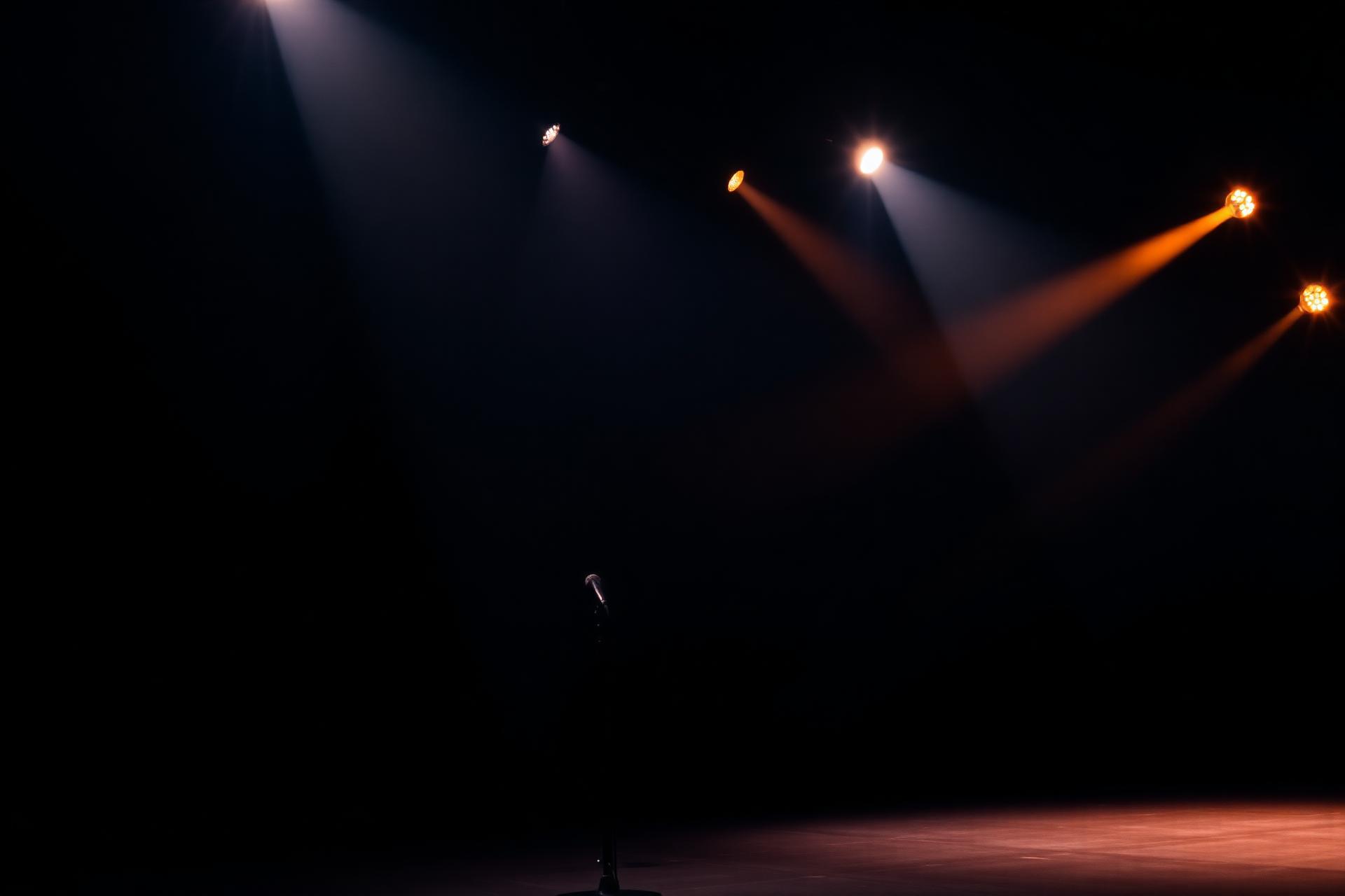 Palco preparado para espectáculo, com feixes de luz quente